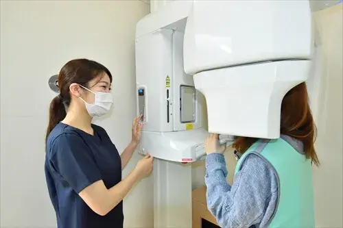 鉛入りのレントゲン防御エプロンを羽織っていただいてのパノラマレントゲン撮影