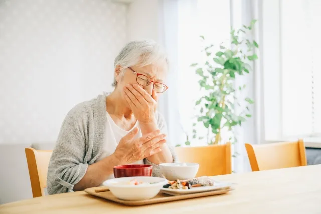 食事中にむせる高齢期の女性(誤嚥性肺炎)
