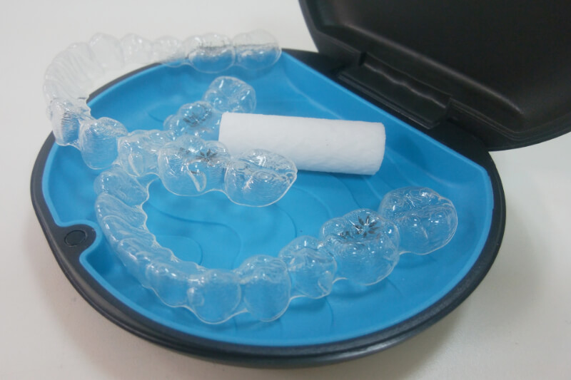 インビザライン装置（上下）と、装着時に欠かせないチューイが入ったインビザライン専用のケース