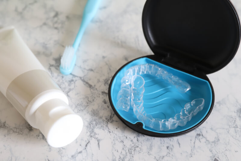 上下のインビザライン装置が入った専用ケースと、歯ブラシと歯磨剤