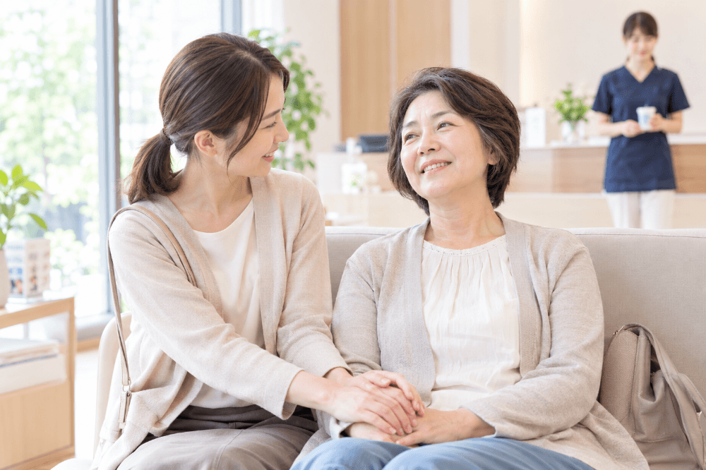 静脈内鎮静法による手術のあと、待合室で付き添いの家族と一緒に休んでいる患者さんのイメージ